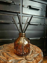 Load image into Gallery viewer, Luxury amber glass diffuser with reed sticks on wooden table against vintage drawers background