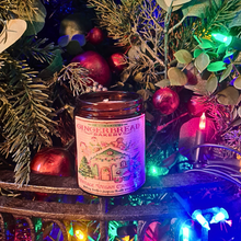 Load image into Gallery viewer, Gingerbread vintage vegan candle in amber jar with Victorian artwork surrounded by festive Christmas decorations and colorful lights