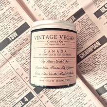 Load image into Gallery viewer, Canada Meadow Lily and Cotton Musk soy wax candle in vintage vegan jar with personalized label and historic newspaper wrapping