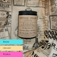 Load image into Gallery viewer, Canada Meadow Lily and Cotton Musk vintage vegan soy wax candle in 180ml jar with personalized label on newspaper wrapping background