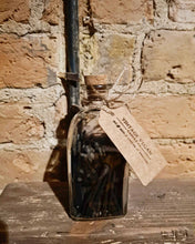 Load image into Gallery viewer, Personalised vintage jar of black candle matches with cork lid and kraft label on wooden surface against brick wall background