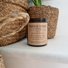 Load image into Gallery viewer, India Lime Basil Mandarin soy wax candle 180ml in amber glass jar with vintage label near woven baskets