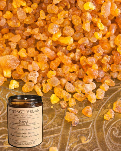 Nepalese frankincense and vanilla soy wax candle with vintage vegan label and resin background