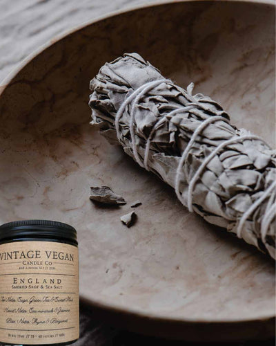 English Sea Salt and Smoked Sage soy wax candle with vintage label and sage bundle in wooden bowl